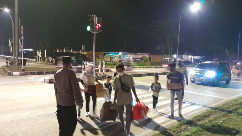Anggota Pos PAM Operasi Ketupat Candi 2022 Exit Tol Salatiga Bantu Seberangkan Jalan Keluarga Pemudik